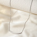 Colar feminino em aço inoxidável com pingente em arco longo.